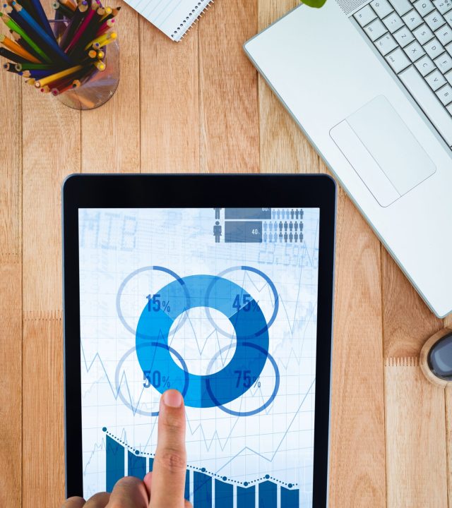 composite of hands using tablet computer with desk background